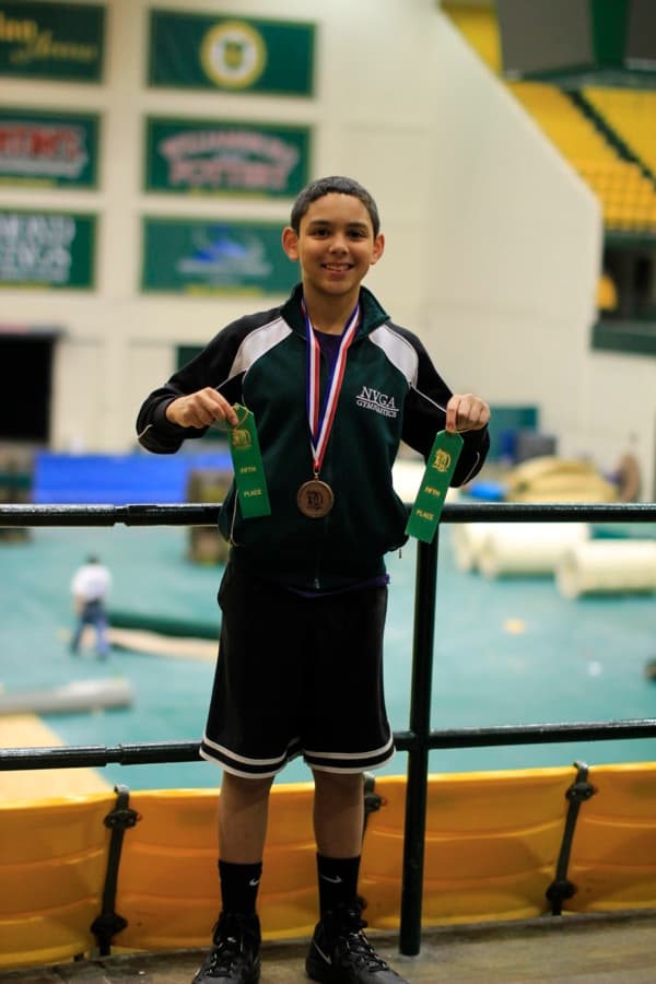 Me holding a medal and ribbons at a Virginia gymnastics meet